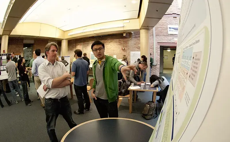 Researchers talking at a conference poster session